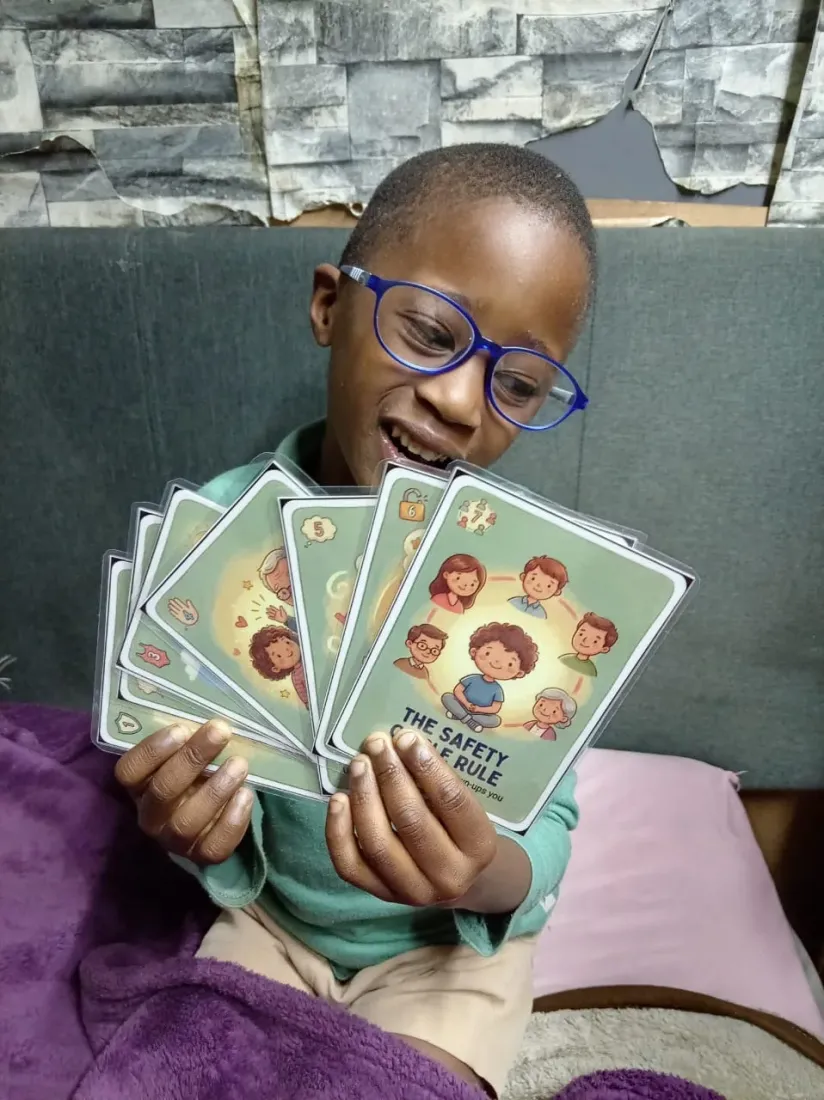 A child at Lolla's Light beaming while holding a fan of Trailies body-safety cards