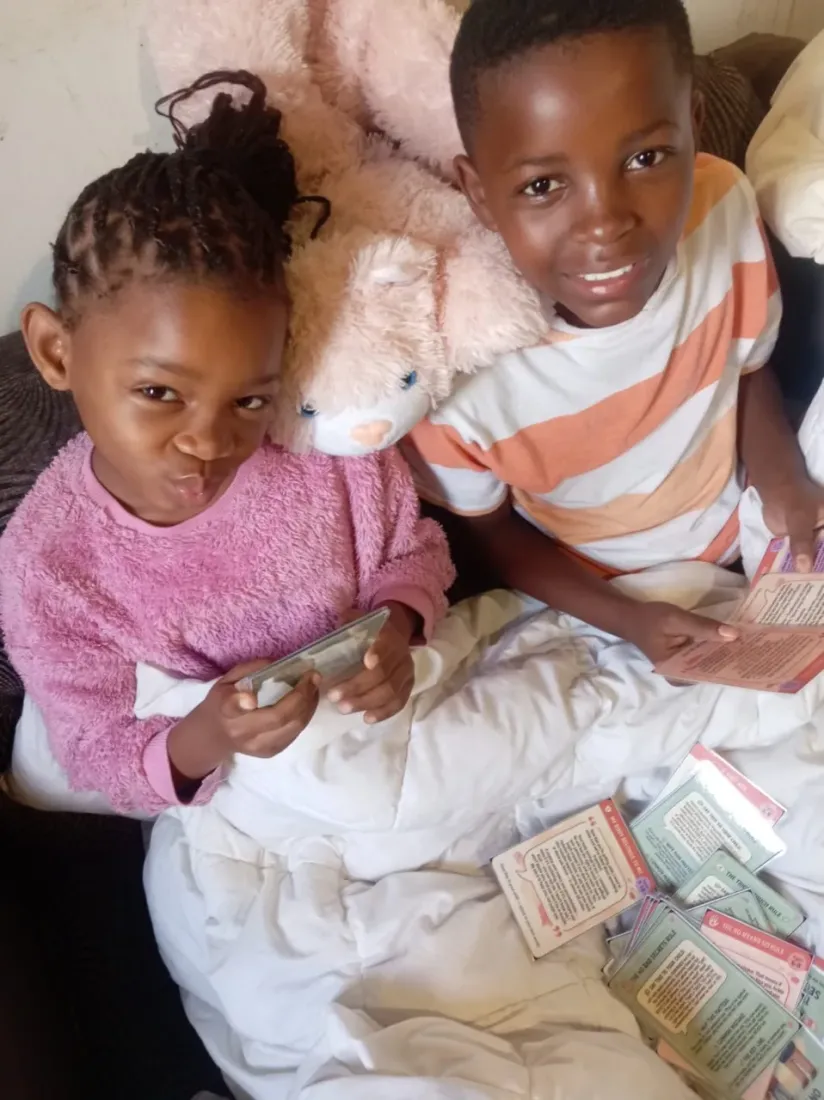 Two kids on the couch reading their gifted Trailies body safety cards together