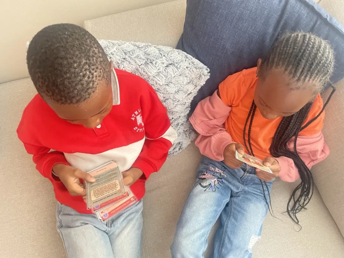 Two children reading Trailies cards together