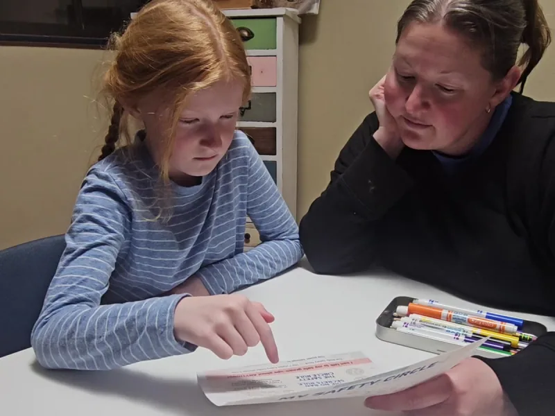 A mom and her daughter filling in the My Safety Circle worksheet together during the Body Safety Talk