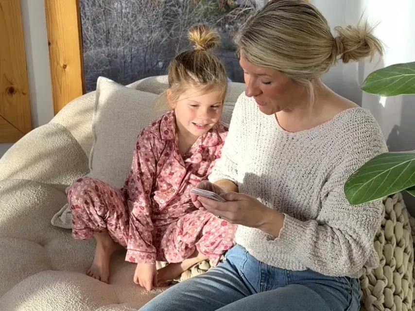 A mom reading the card word-for-word to her child at bedtime