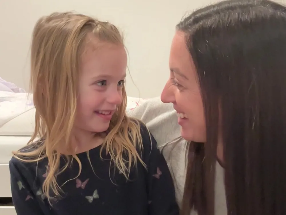 A mom and her daughter laughing together mid Talk