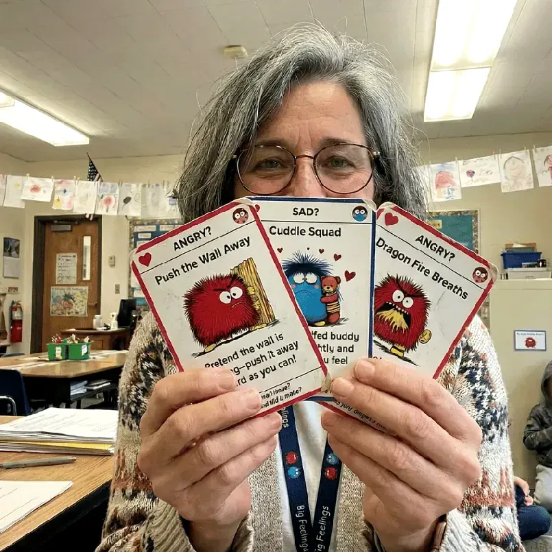 Debbie, co-founder of Trailies, holding Big Feelings cards in her classroom